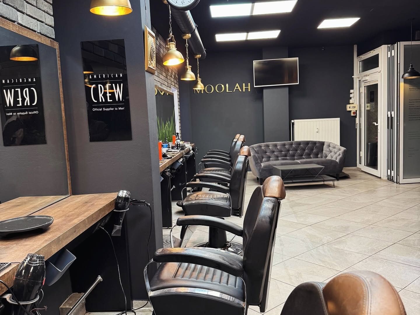 Reihe der Friseurstühle, im Hintergrund der Moolah-Schriftzug